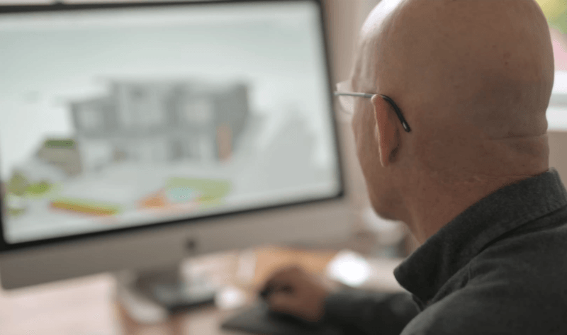 Chris Walker reviewing a custom home conceptual drawing on his computer