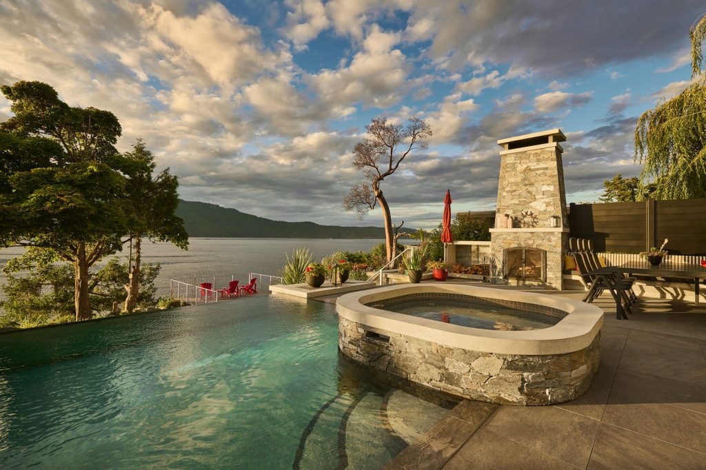 pool with hot tub and outdoor fireplace